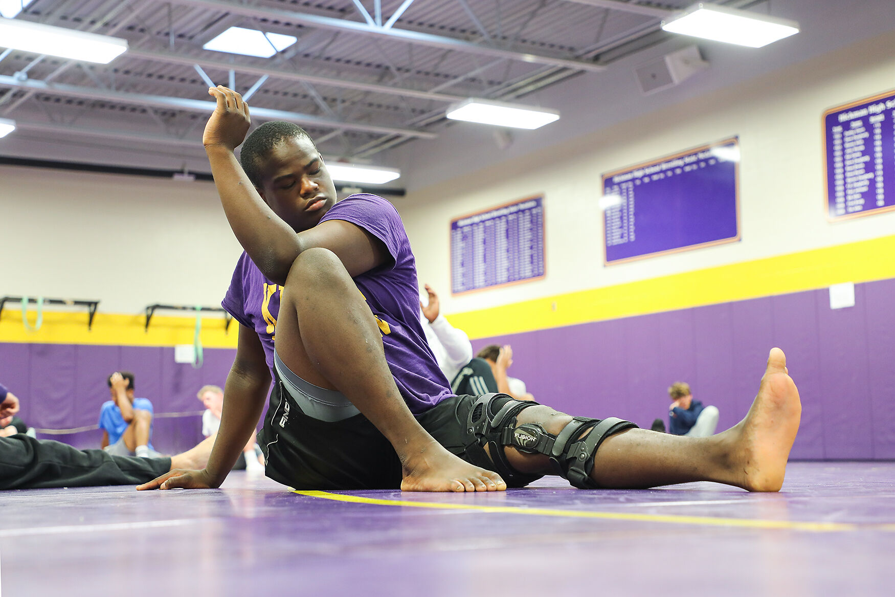 Kole Jackson stretches during a group yoga session for the varsity football players